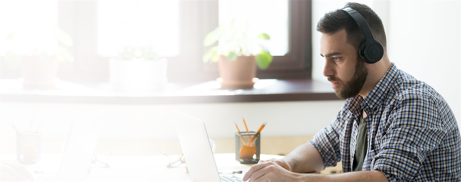 A developer working at a laptop, comparing cross-platform build tooling